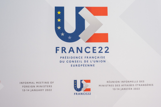 Plakat für die "Frankreich 22 - Informelle Tagung der ausländischen Minister" mit dem Logo der Europäischen Union, das einen blauen Kreis, einen weißen Rand und einen zentralen weißen Stern zeigt.