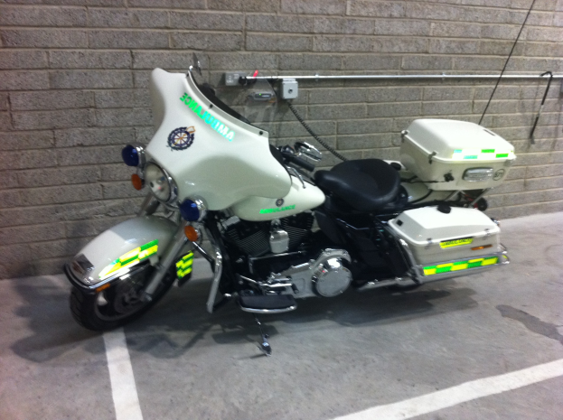 Ein Polizeimotorrad, das in einer Tiefgarage neben einer Backsteinwand geparkt ist.