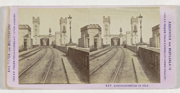 Schwarz-weiß-Stereoskopiebild einer Zugstrecke mit der Eisenbahnbrücke-Brüccke in Köln, Deutschland, zeigt Schienen, Wände, Pfosten, Statuen, Himmel und Text.
