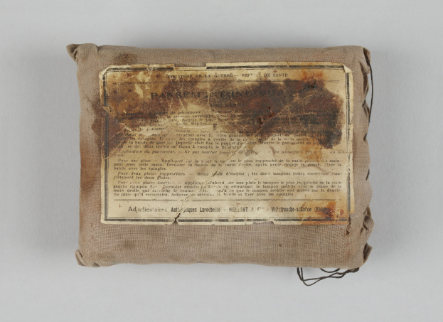 Kleiner Verbandskasten mit einer Papierzettel oben drauf.