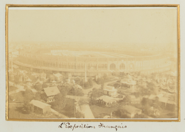 Altes Schwarz-Weiß-Foto eines Stadions inmitten einer Stadt, umgeben von Gebäuden, Bäumen und Strommasten, mit Text unten.