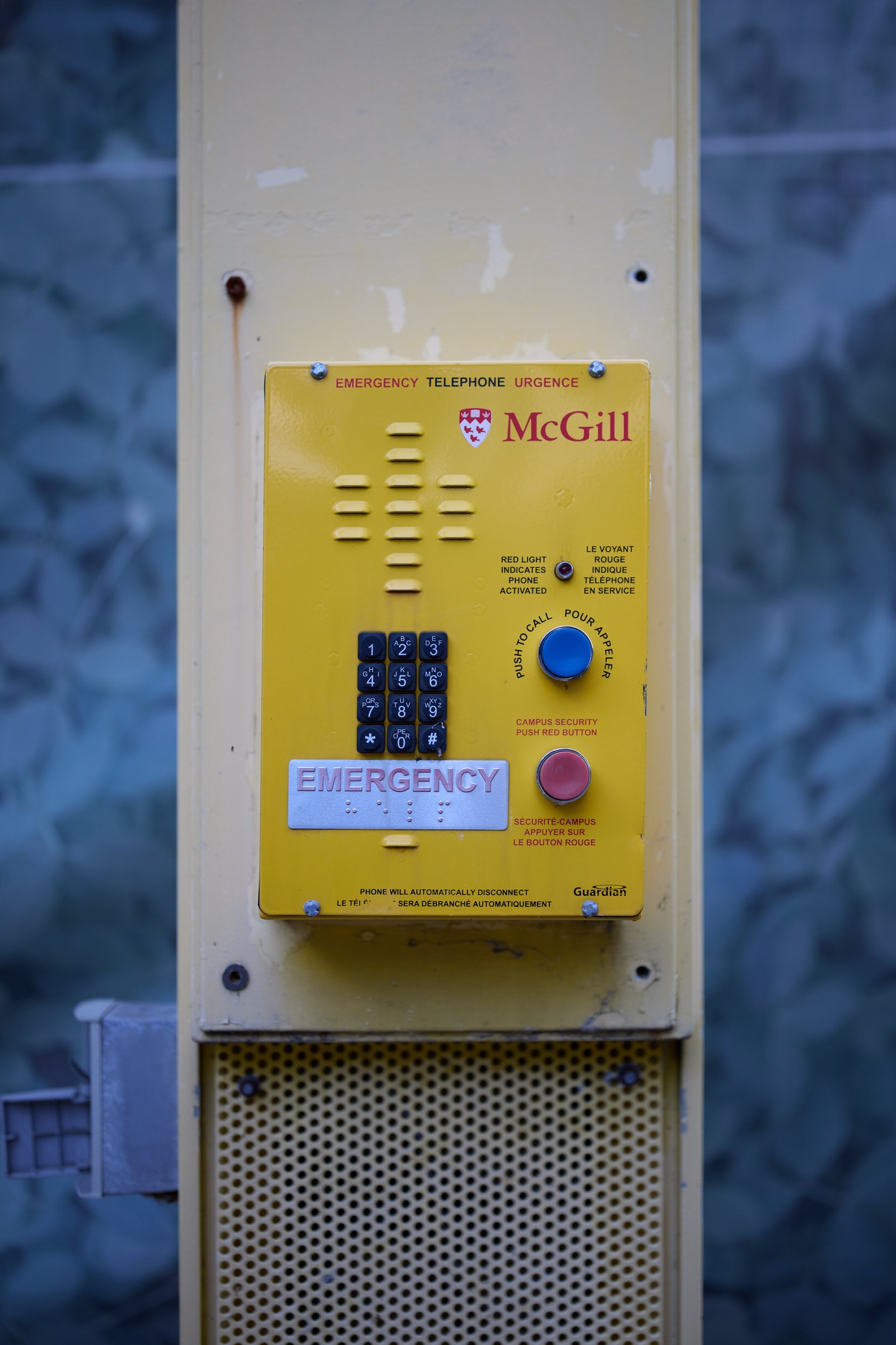 Gelber Notrufhörer an einer Gebäudewand montiert, für Notrufe entworfen.