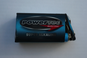 Blue Powertec Super Alkaline battery on a white surface with "Powertec" in bold lettering.