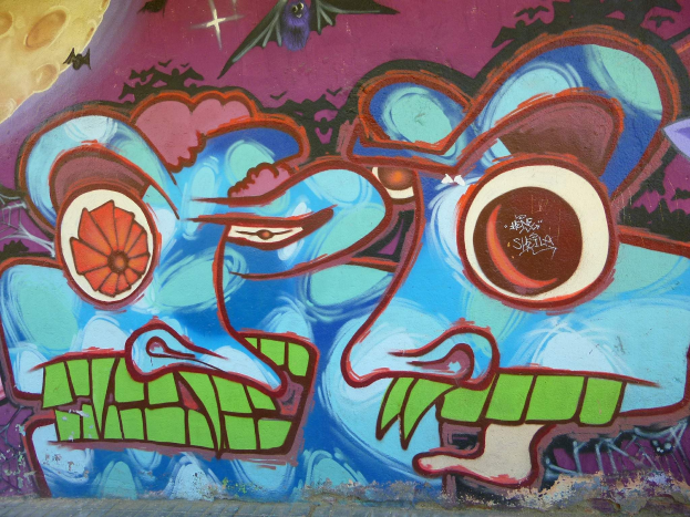 Ein leuchtendes, farbenfrohes Wandgemälde an der Seite eines Gebäudes mit Graffiti-Kunst.