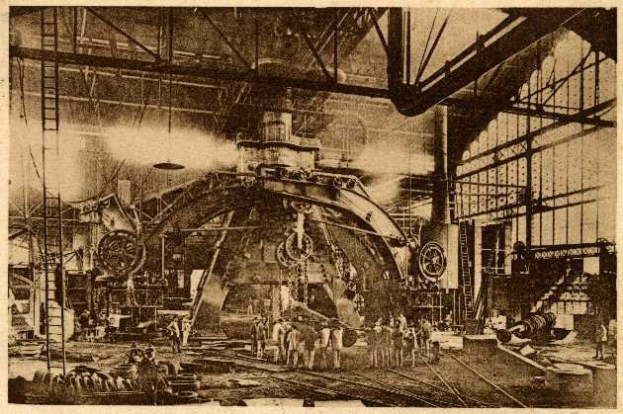 Schwarzes und weißes Foto einer Fabrikhalle mit Arbeitern, die eine große Maschine bedienen, umgeben von Leitern und Stangen, beschriftet mit "Cadillac Steel Works" unten.
