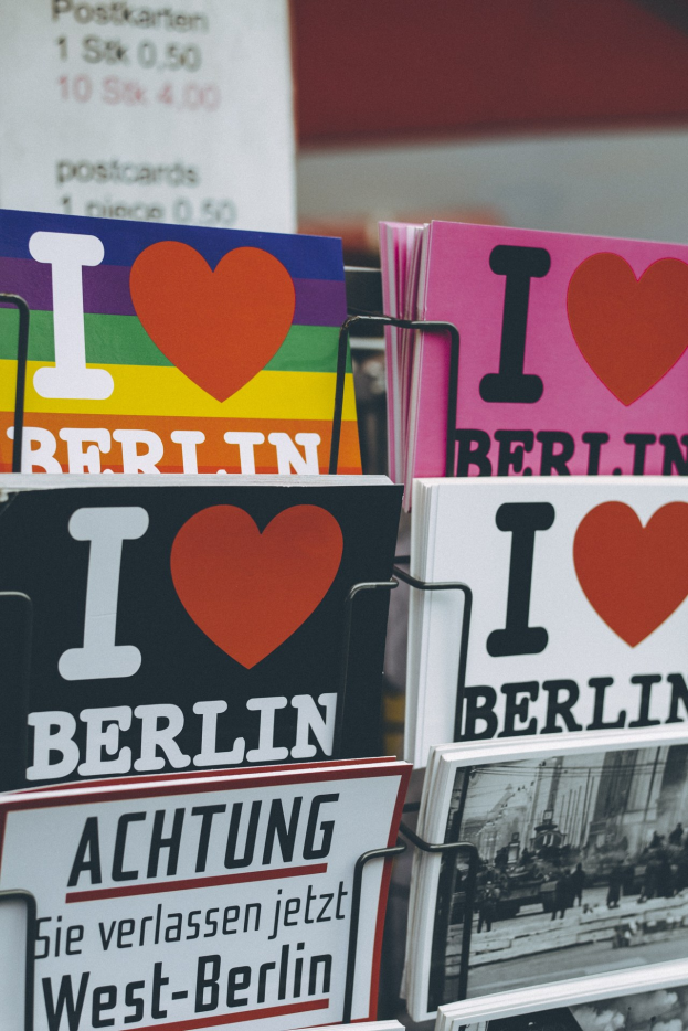 Ein Gestell mit verschiedenen Büchern und Plakaten mit der Aufschrift "Ich liebe Berlin" vor einem leicht unscharfen, traumhaften Hintergrund.