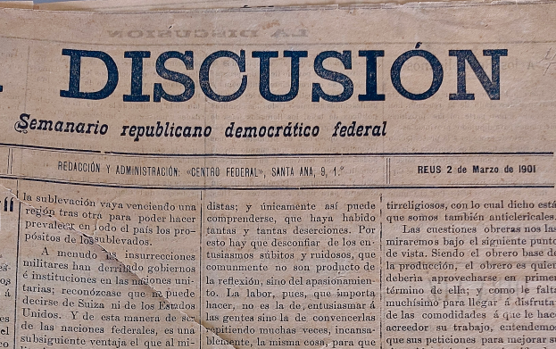 Eine vergilbte, leicht zerknitterte Zeitung mit der schwarzen Schrift 'Diskussion' darauf, die die Schlagzeile 'Semanario Repúblicano Democrático Federal' trägt.