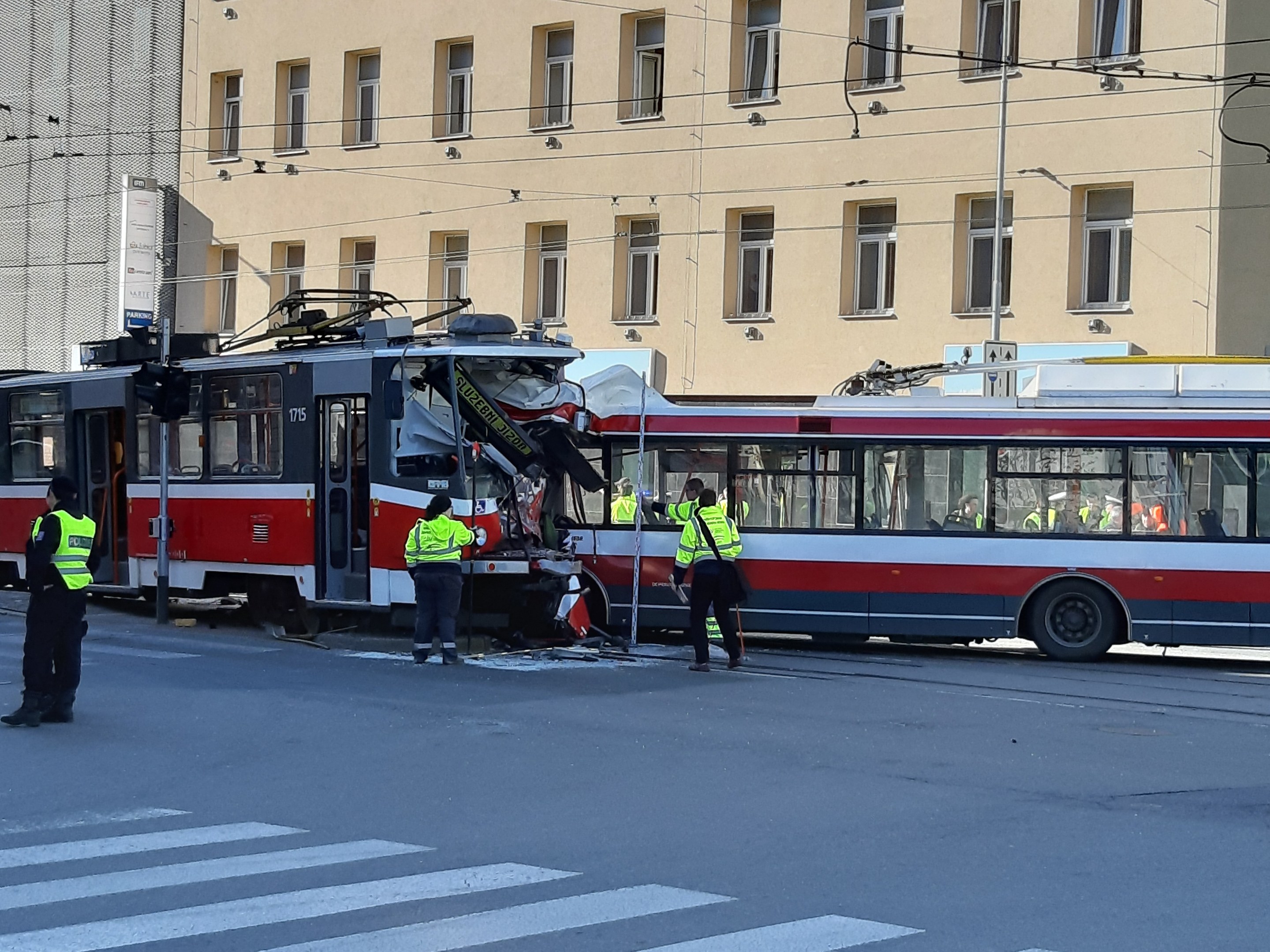 Rote und weiße Straßenbahn krachte auf der Seite der Straße mit einigen Menschen in der Nähe und einem Gebäude im Hintergrund.