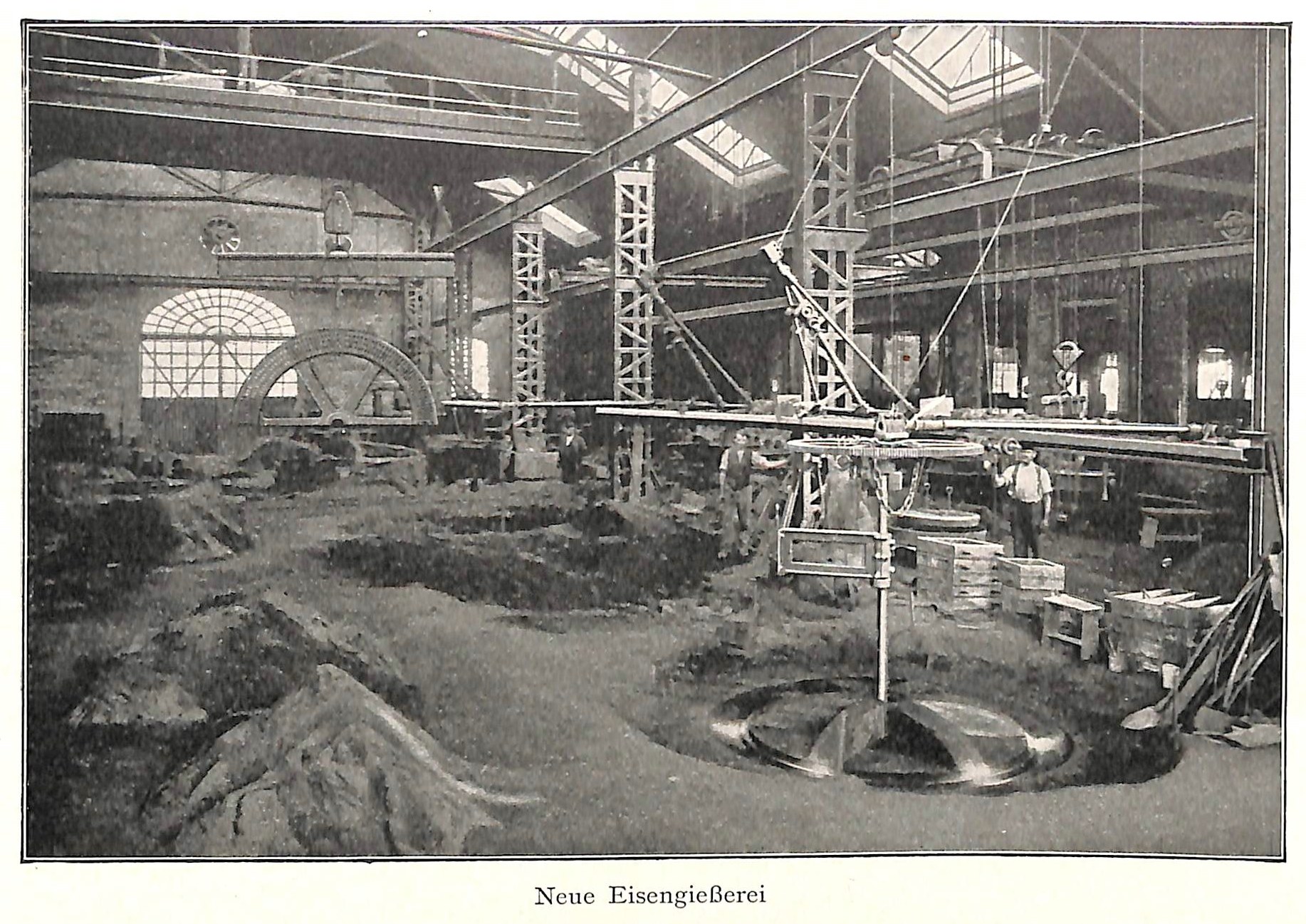 Schwarze und weiße Fotografie eines Fabrikinneren mit Arbeitern, die Maschinen bedienen, Metallstangen und -pole, beschriftet mit "Neue Eisengießerei, die erste Fabrik in Deutschland" unten.