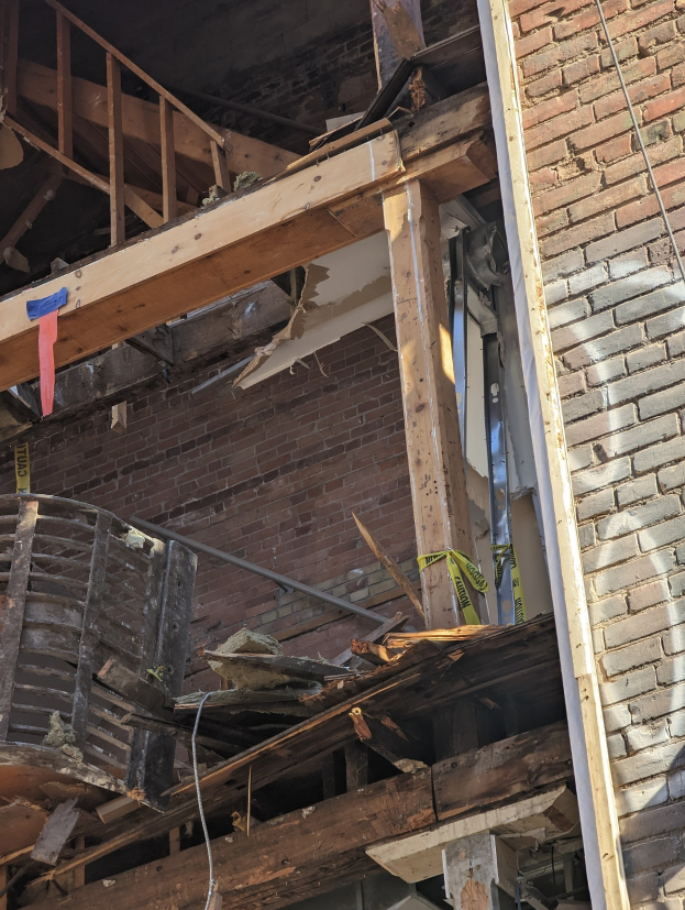 Ein teilweise abgerissenes Gebäude mit verstreuten Holzplanken und Trömmern sowie zerbrochene Fenster und Türen im Anschluss an die Abrissarbeiten.