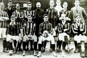 Ein Schwarz-Weiß-Foto einer Fußballmannschaft, die vor einer Wand steht oder sitzt, mit dem Text "Ballymena Football Club" unten.