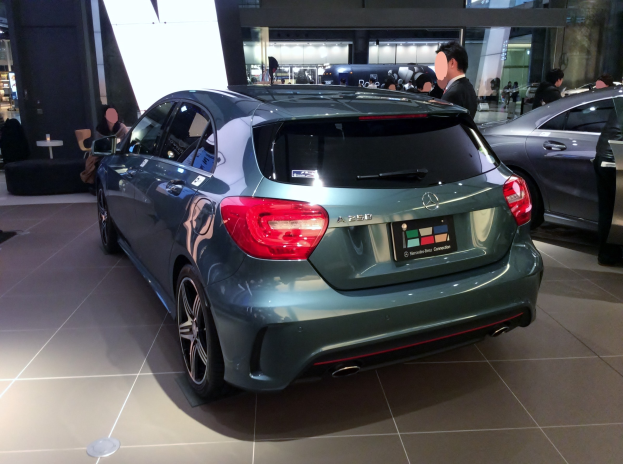 Mercedes-Benz A-Klasse Schrägheck mit glänzender schwarzer Lackierung, Chromakzenten und Aluminiumrädern auf der IAA in Frankfurt umgeben von Menschen.